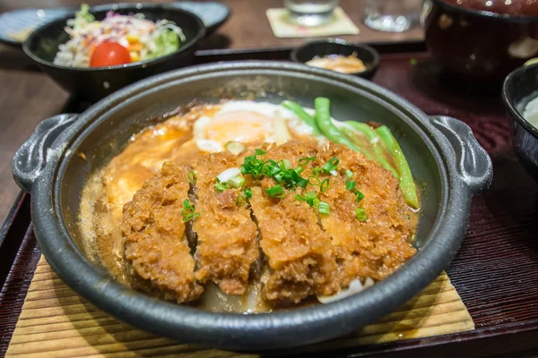 Жареная свинина, сваренная со свежим яичным топом на миске с рисом. основная японская еда — стоковое фото