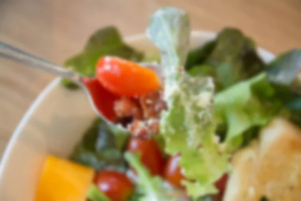 Onscherpe achtergrond van frisse salade met becon, kaas en tomaat. — Stockfoto