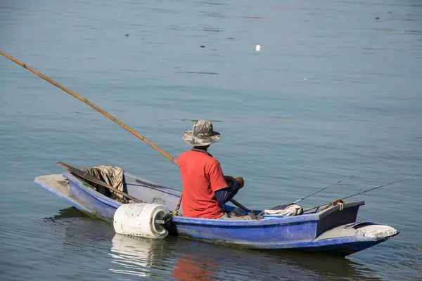 Fisherman in fishing boat on water — Stock Photo, Image