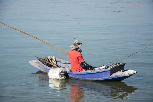 Fisherman in fishing boat on water — Stock Photo, Image