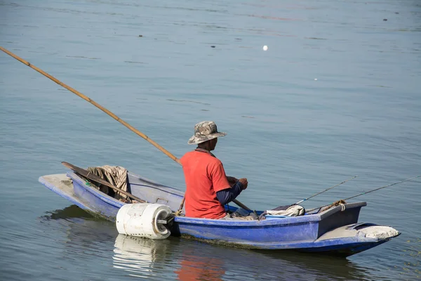 Fisherman in fishing boat on water — Stock Photo, Image