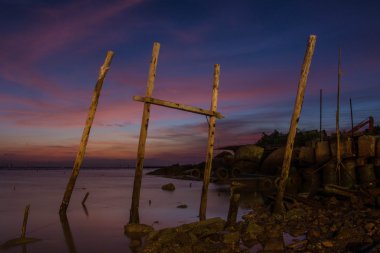 Bangpu, Tayland Samutprakarn alacakaranlıkta denizde üzerinde ahşap kazık
