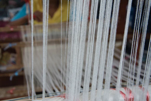 close up of weaving silk in traditional way at manual loom. Thailand
