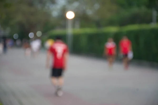 Blurred background of people running in park — Stock Photo, Image