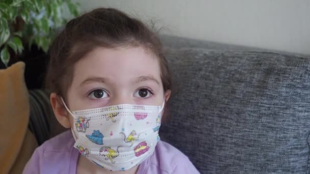 Dítě nosí lékařskou masku a poslouchá matku během domácí karantény. COVID-19 — Stock video