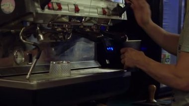 Gece geç saatlerde barın dışında kahve kapuçinosu hazırlayan barmen.