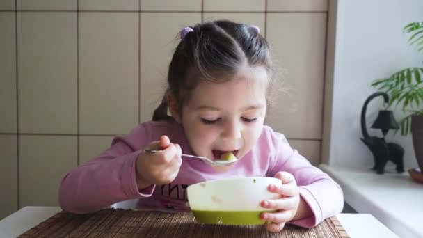 Adorable niña le gusta comer sopa de verduras con buen apetito. — Vídeo de stock