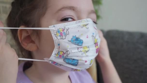 Een kind met een medisch masker thuis in quarantaine. Concept van het coronavirus COVID-19 — Stockvideo