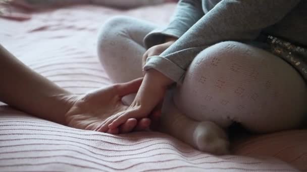 Menina criança pré-escolar segurando suas mães adoráveis mão durante o dizendo uma cauda de fada e sentados na cama juntos. Fechar — Vídeo de Stock