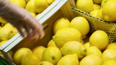 Kadınlar bakkaldan taze limon ve lateks eldiven seçerler. C vitamini.