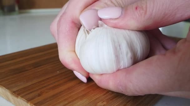 Femme épluchant la peau de la gousse d'ail sur une table en bois. Ralentir mo Fermer — Video