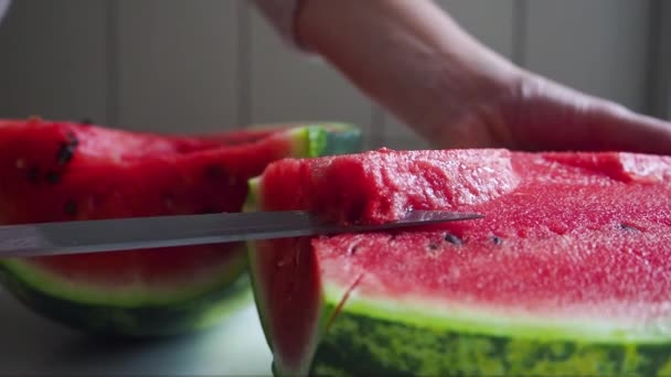 Female cut the tastiest part of watermelon with a big metallic knife. Close up — Stock Video