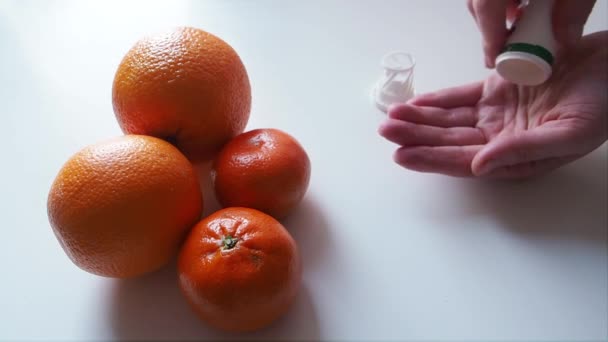Mulher leva Vitamina C à mão com fundo de laranjas na mesa Acima Fechar — Vídeo de Stock