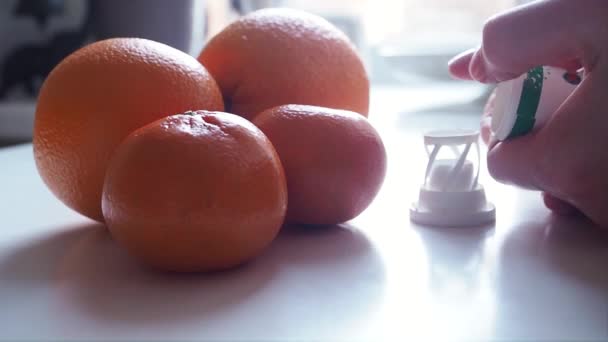 Woman takes Vitamin C to hand with background of oranges on table Close up — Stock Video