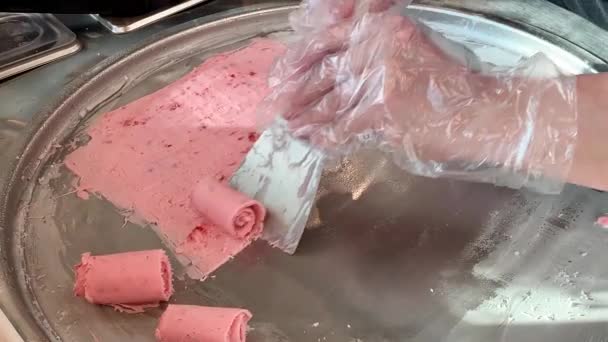Rolando sorvete de morango natural em estilo tailandês na panela de congelamento. Sobremesa de baunilha doce caseira em placa fria — Vídeo de Stock