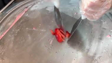 Kadın dondurucuda kızarmış dondurma hazırlayan çilek dilimleri. Soğuk tabakta ev yapımı sağlıklı tatlı.