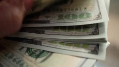 Yüz dolarlık banknotları sayarken ellerinizi yakın tutun. 100 Amerikan nakitinin yeni banknotları.