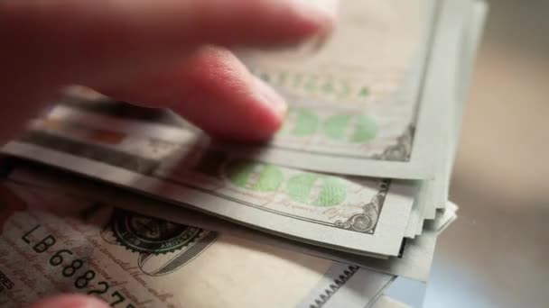 Dedos femeninos golpeando el dinero en la mesa de cristal. Billetes de 100 dólares americanos en efectivo. Macro de cerca — Vídeos de Stock