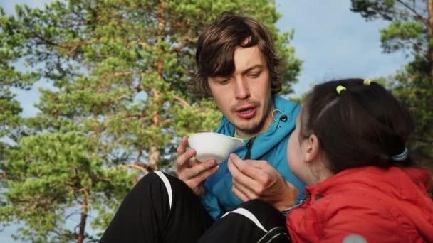 El padre joven explica seriamente las reglas de seguridad a su hija durante el desayuno de camping en vacaciones de primavera. Aventura Recreación Vacaciones y Viajes Estilo de Vida Concepto. — Vídeos de Stock
