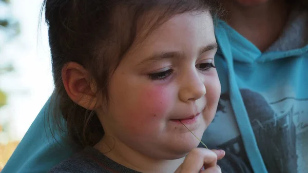 Aşırı derecede yakın. Gün batımında kamp yaparken annesinin cep telefonuyla servis ağını karıştırmasıyla gülümseyen küçük siyah saçlı ve pembe yanaklı kız. Doğanın nitelikli aile zamanı kavramı