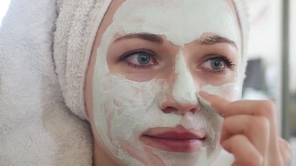 Ferme là. Femme séduisante d'âge moyen applique masque cosmétique carbo détox argile vert clair sur son visage devant un miroir. Fille prenant soin du teint gras de la peau. Soins de beauté. Soins de la peau — Video