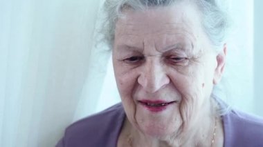 85 yaşındaki muhteşem son sınıf anneannesi, yüzü kahverengi gözlü, beyaz saçlı ve kameraya bakan büyük kırışıklıkları var. Uzun ve sağlıklı aktif yaşam konsepti boyunca doğal güzellik