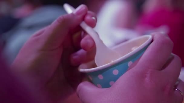 Woman eating vanilla ice-cream with plastic spoon from paper cup. close up — Stock Video