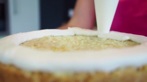 Chef piping out crème remplissage sur un gâteau éponge à l'aide d'un sac à pâtisserie. Gros plan — Video