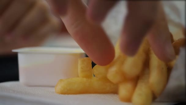 Женские руки макают картошку фри в соусе из горчичного сыра. Закрыть — стоковое видео