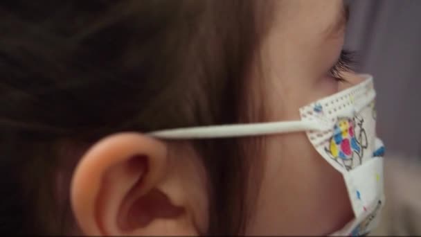 Girl wears medical kids mask with pictures from coronavirus. Close up — Stock Video