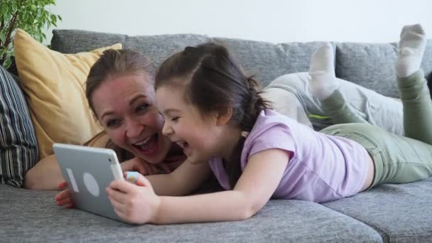 Gelukkig moeder en meisje gebruik digitale tablet thuis in quarantaine voor Coronavirus. Sluiten. — Stockvideo