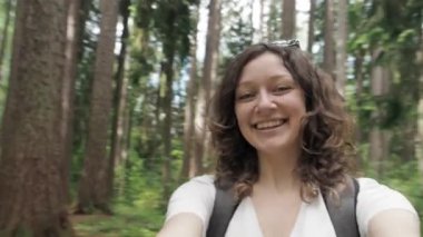 Mutlu, neşeli ve heyecanlı genç bir kız akıllı telefon kamerasında video selfie çekiyor, parkta yürürken etrafında dönüyor. Dünyayı dolaş, hayallerin peşinden git, macera yaşam tarzı. Bakış açısı