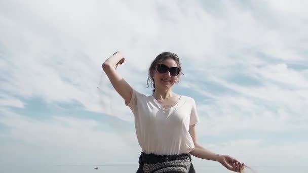 Kaukasische niedliche Dame glücklich und lächelnd am Strand Sommer schnappt sich eine Handvoll trockenen Sand und lässt es fallen. Zeit genießen — Stockvideo