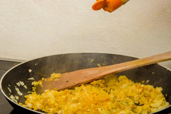 在热锅里放一些印度咖哩在洋葱和其他调味品的混合物上 — 图库照片