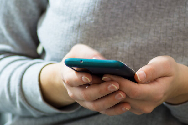 Frontal view of woman's beautiful hands using the smartphone