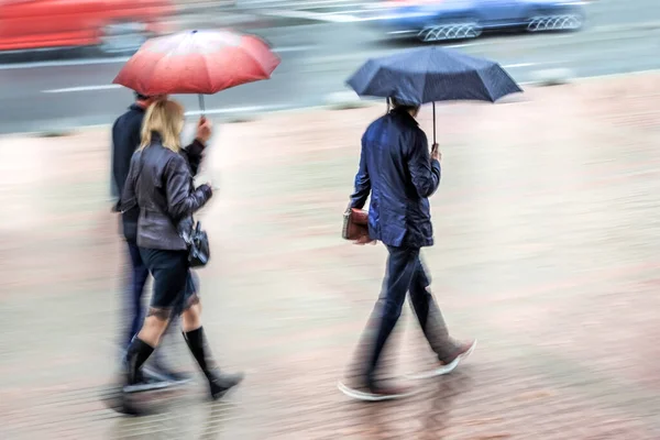 雨の日の動きで街を歩くビジネスマンが — ストック写真