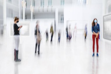 Bulanık bir geçmişi olan modern bir sanat merkezinin lobisindeki insanların soyut görüntüsü.