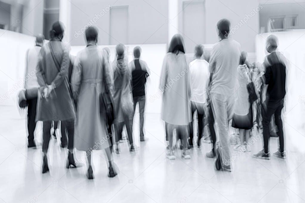 abstract image of people in the lobby of a modern art center with a blurred background