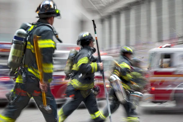 Vrachtwagens en brandweerlieden brandweer in de stad — Stockfoto