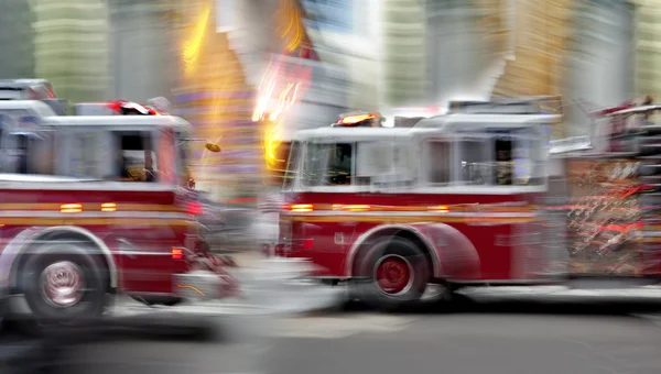 Vrachtwagens en brandweerlieden brandweer in de stad — Stockfoto