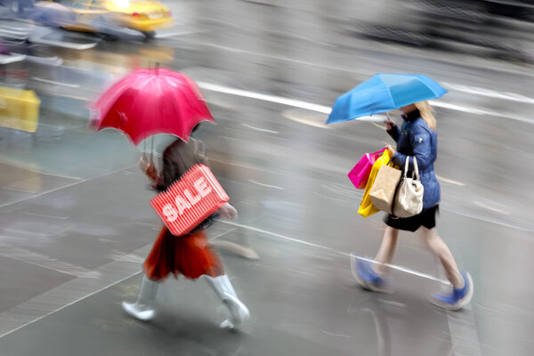 Люди ходят по магазинам в городе в дождливую погоду
    