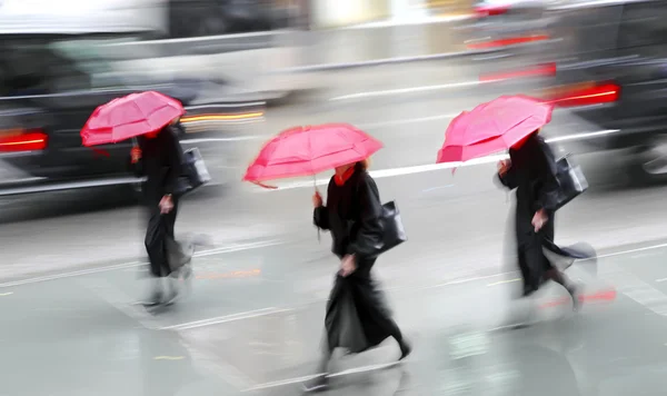Ludzie biznesu spaceru na ulicy, na deszczowy dzień ruchu rozmycie — Zdjęcie stockowe