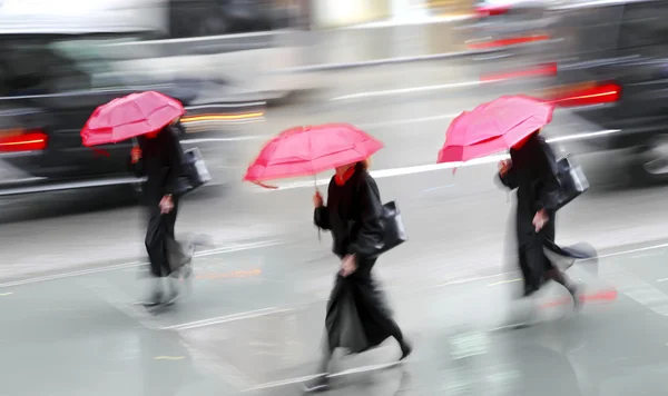 Gente de negocios caminando en la calle en un día lluvioso movimiento borroso — Foto de Stock