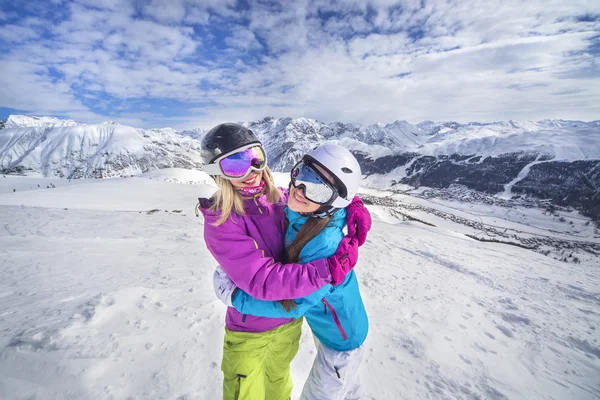 Gelukkig meisjes op een besneeuwde berg skiresort Stockfoto