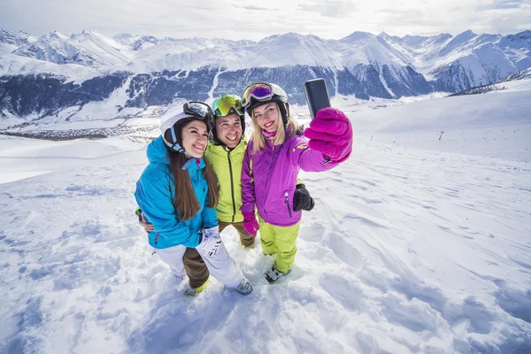 Jonge mensen zijn het maken van mobiele selfie skiresort Stockfoto