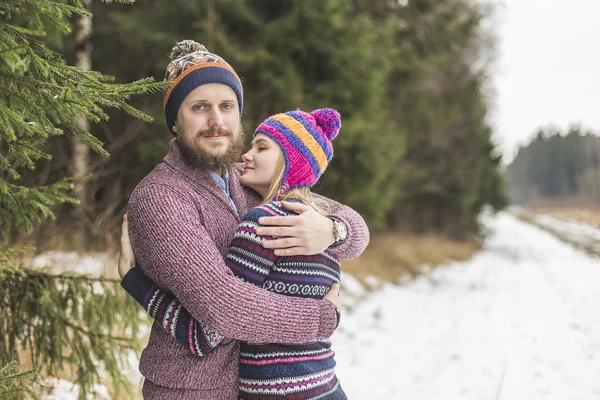 Junges Paar umarmt sich im Winterwald — Stockfoto