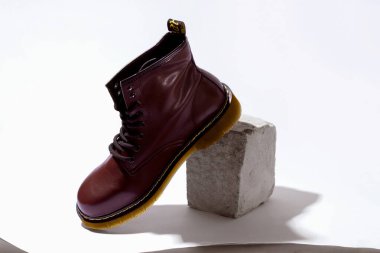 Beyaz taşın üzerinde sonbahar çizmesi.