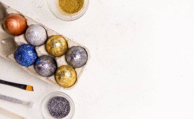 Paskalya için. Beyaz arka planda parıltılı yumurtalar. Uzayı kopyala Yukarıdan görüntüle