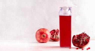 Gri arka planda nar suyu bulunan sahte bir şişe. Uzayı kopyala Pankart