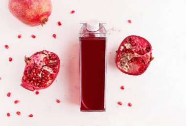 Beyaz arka planda nar suyuyla şişeleri taklit et. Yukarıdan görüntüle